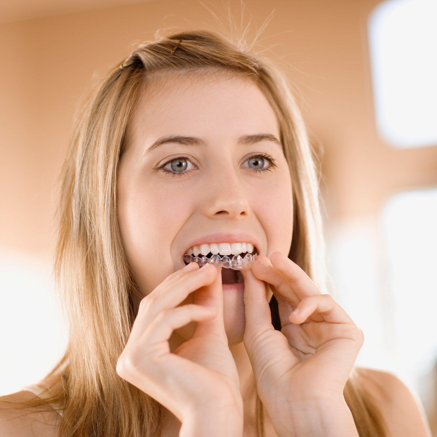 Cosmetic Dentistry — Woman Putting Invisible Orthodontics in Akron, Oh