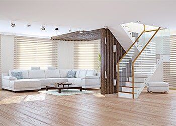 A room decorated with our blinds and shades in Santa Monica, CA A living room with a couch , coffee table , and stairs.