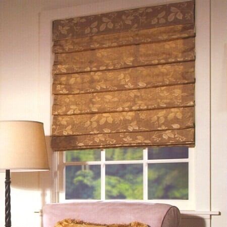 A living room with a couch a lamp and a roman shade
