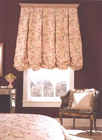 A bedroom with a bed a chair and a window