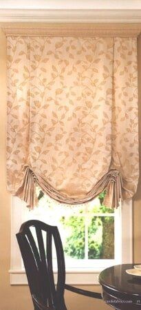 A chair is sitting in front of a window with a curtain on it.