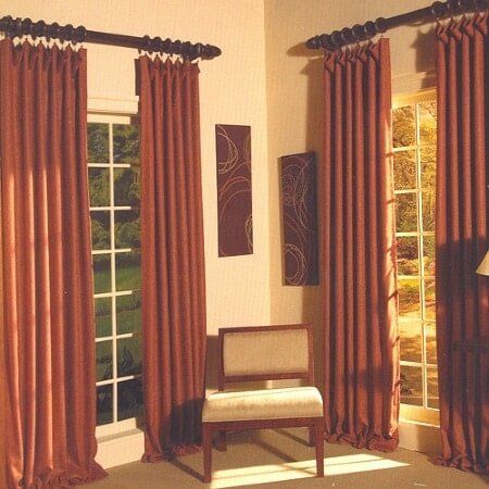 A room with brown curtains and a chair