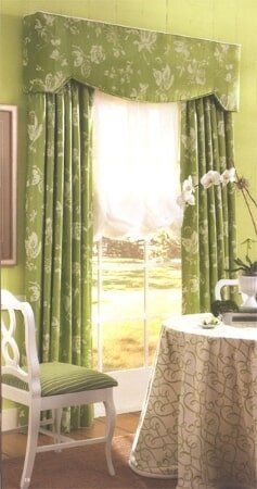 A room with green curtains and a table and chairs