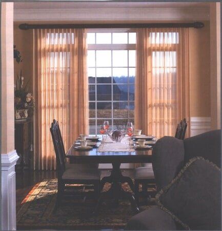 A dining room with a table and chairs and a large window