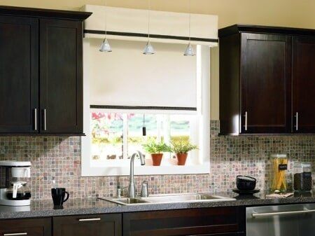 A kitchen with dark wood cabinets and a stainless steel dishwasher
