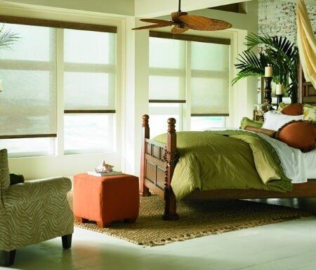 A bedroom with a canopy bed and a ceiling fan