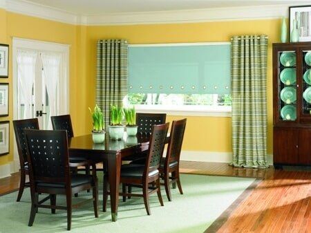 A dining room with a table and chairs and yellow walls