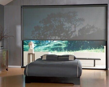 A bedroom with a large window and a bed