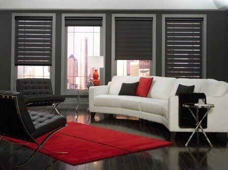 A living room with a white couch and black chairs