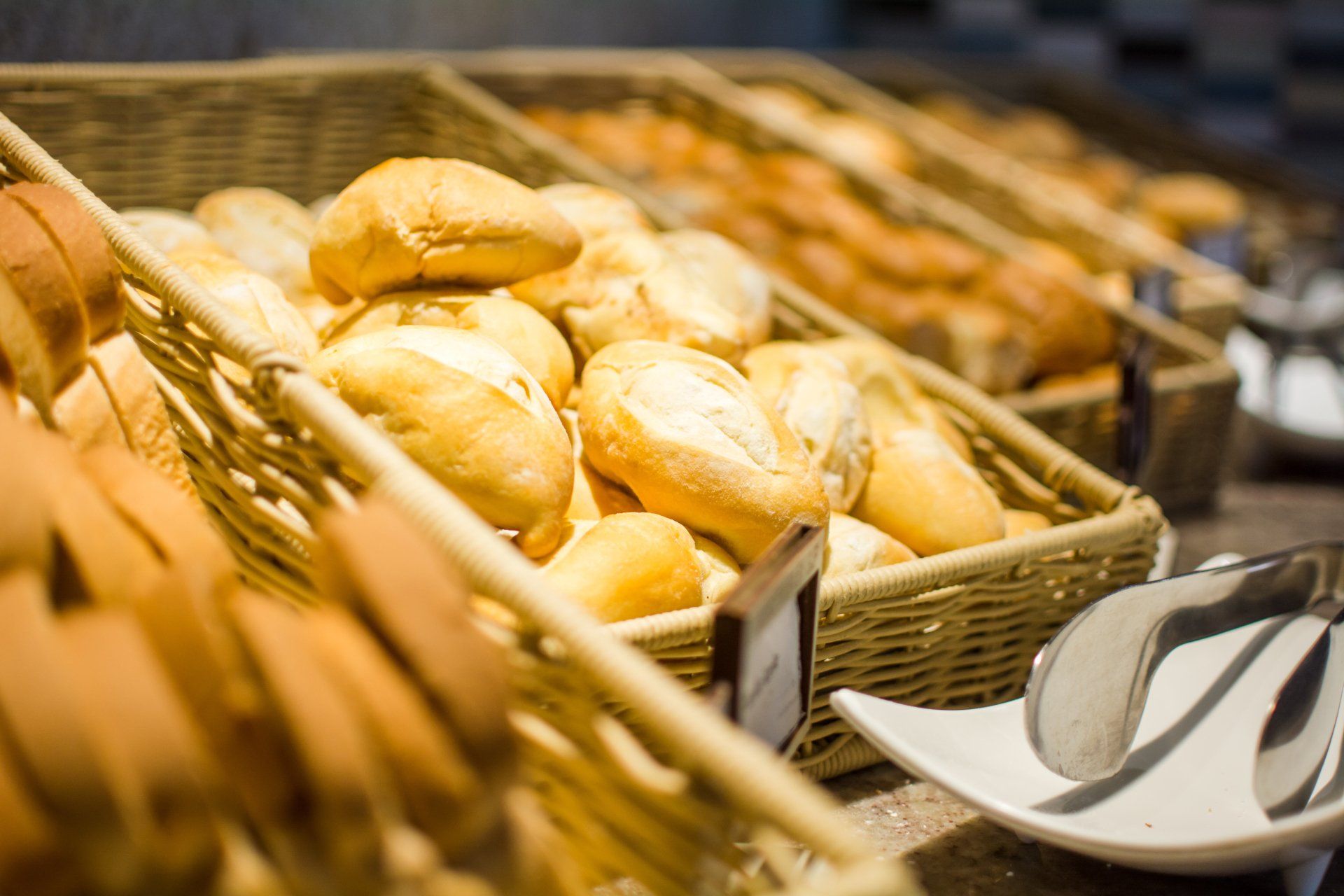 Há muitas cestas de pão na mesa.