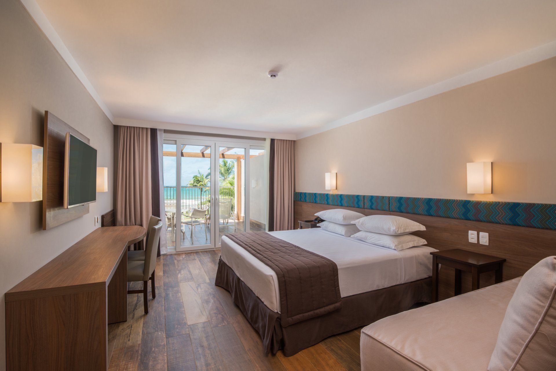 Um quarto de hotel com uma cama king size e uma TV de tela plana.