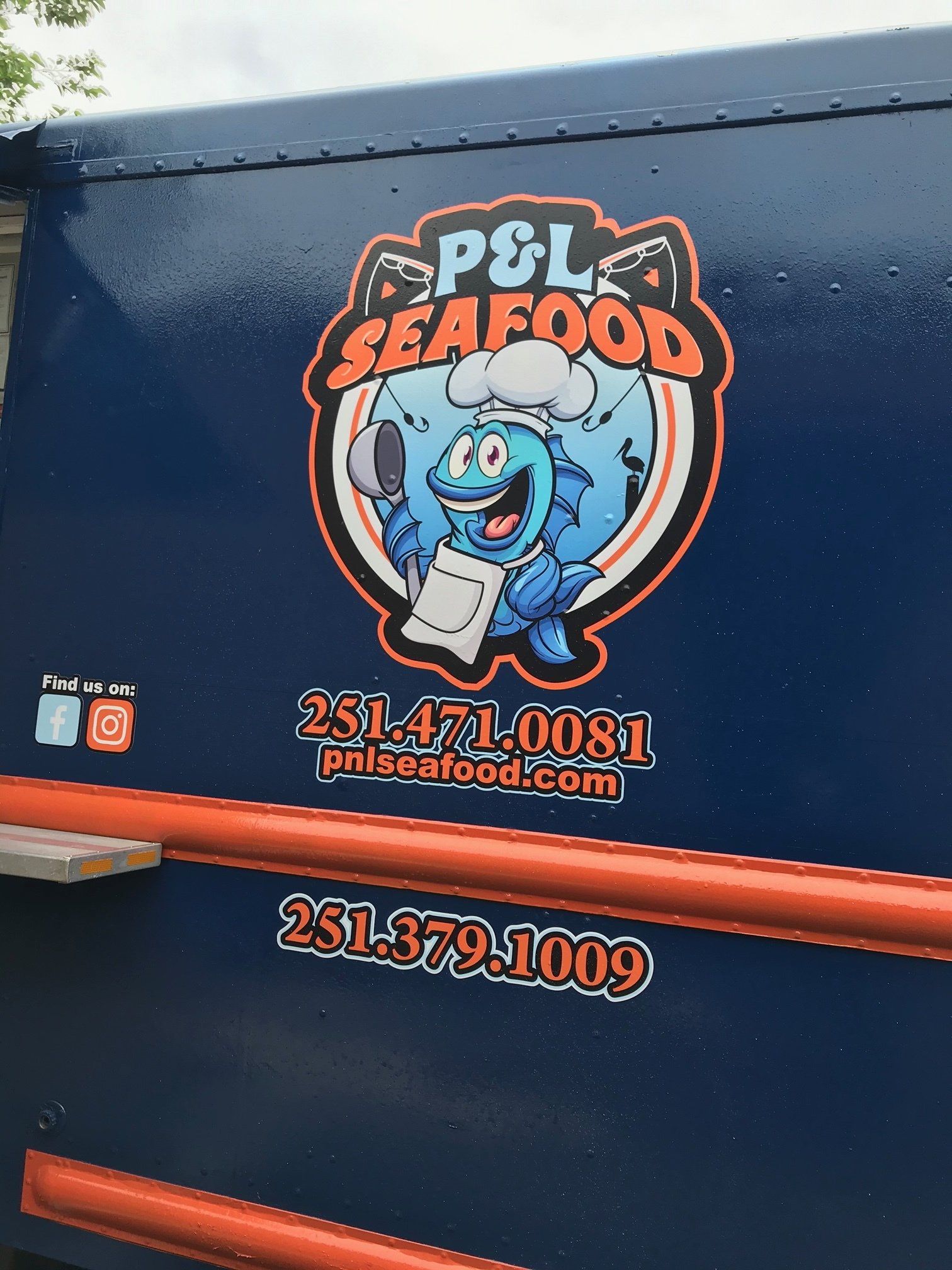 Side of a blue P&L Seafood food truck with a cartoon fish chef logo, website, and phone numbers in orange text.