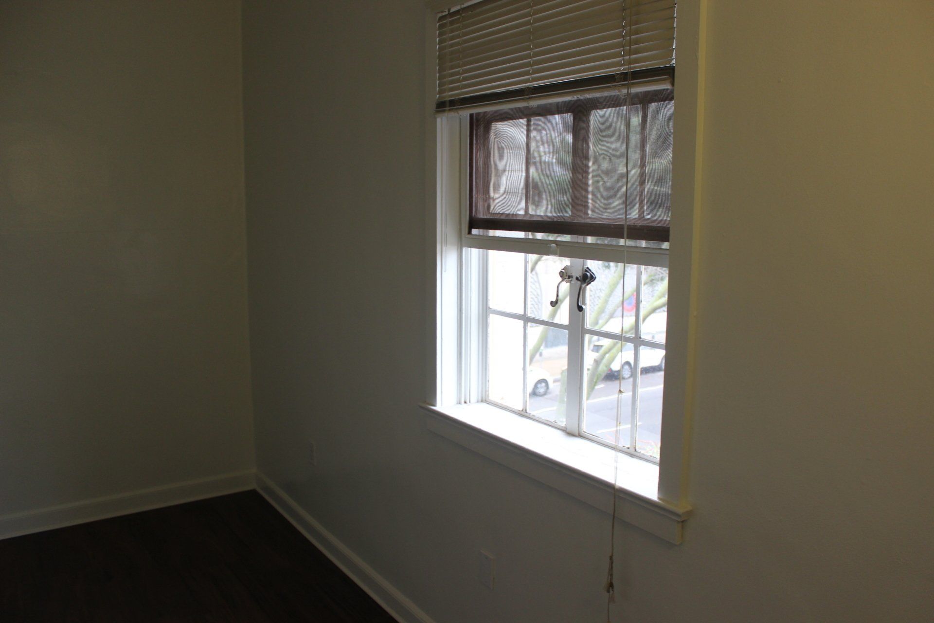 An empty room with a window and blinds on it.