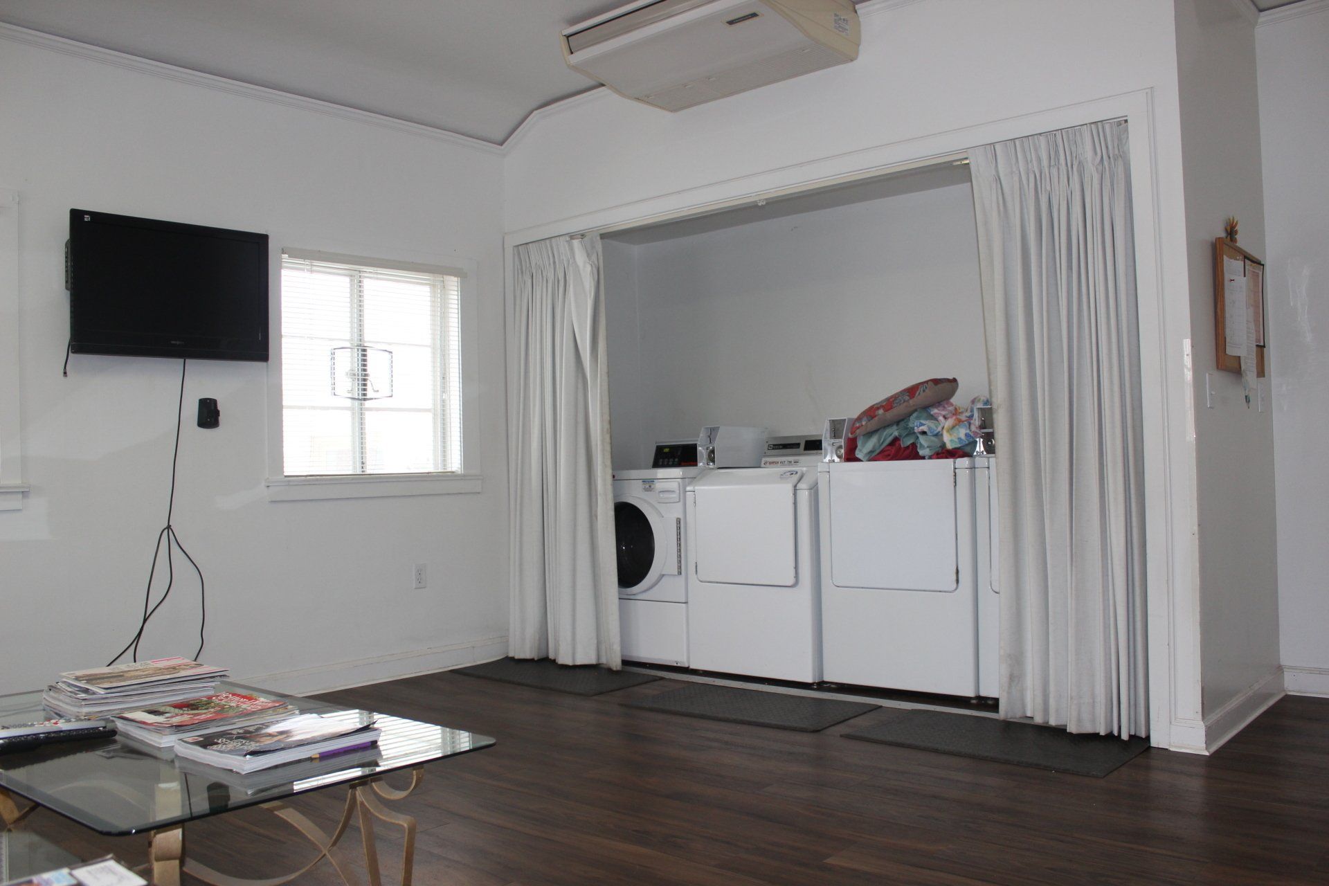 A laundry room with a washer and dryer and a flat screen tv.
