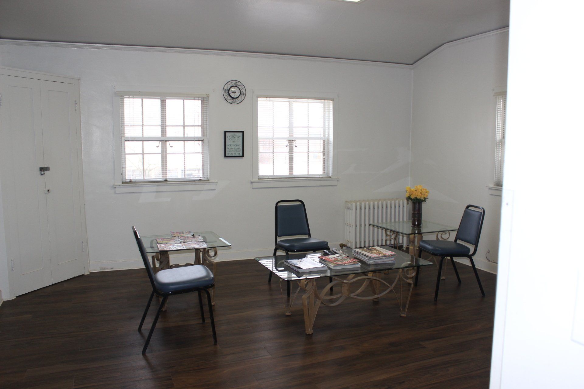A room with a table and chairs and a clock on the wall