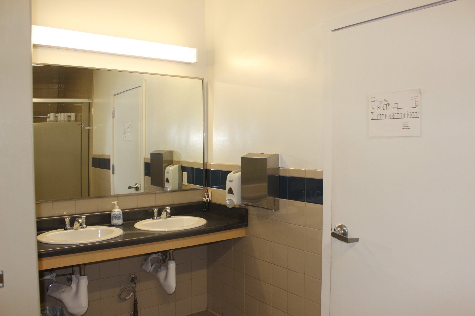 A bathroom with two sinks and a mirror.