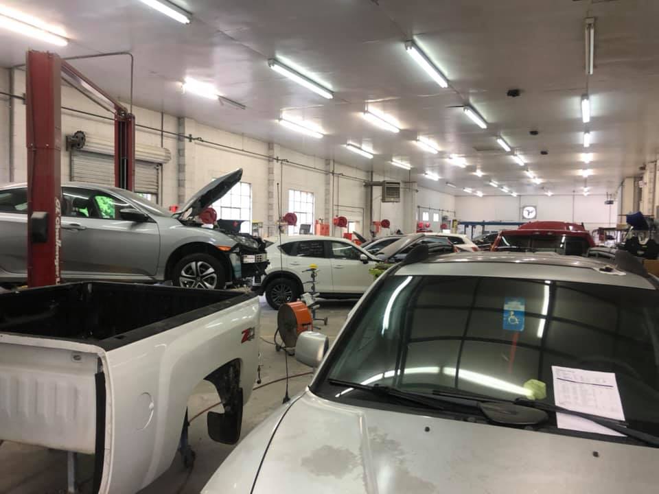 A lot of cars are being worked on in a garage.