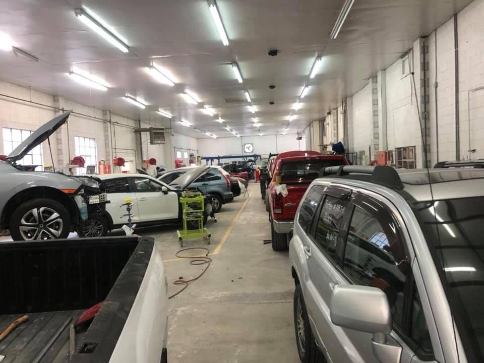 A row of cars are parked in a garage.