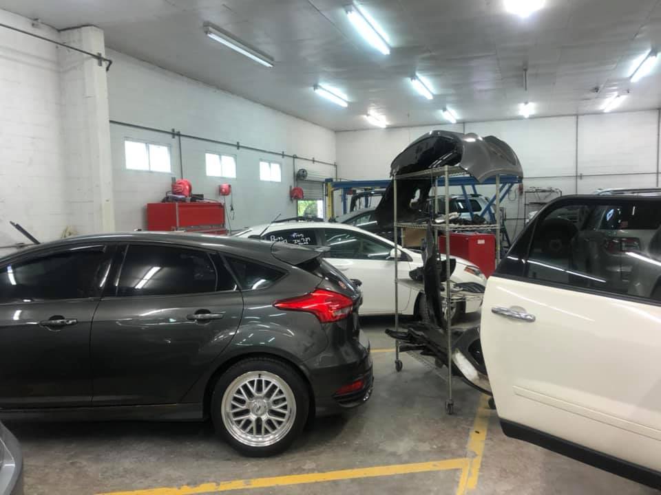 A row of cars are parked in a garage.