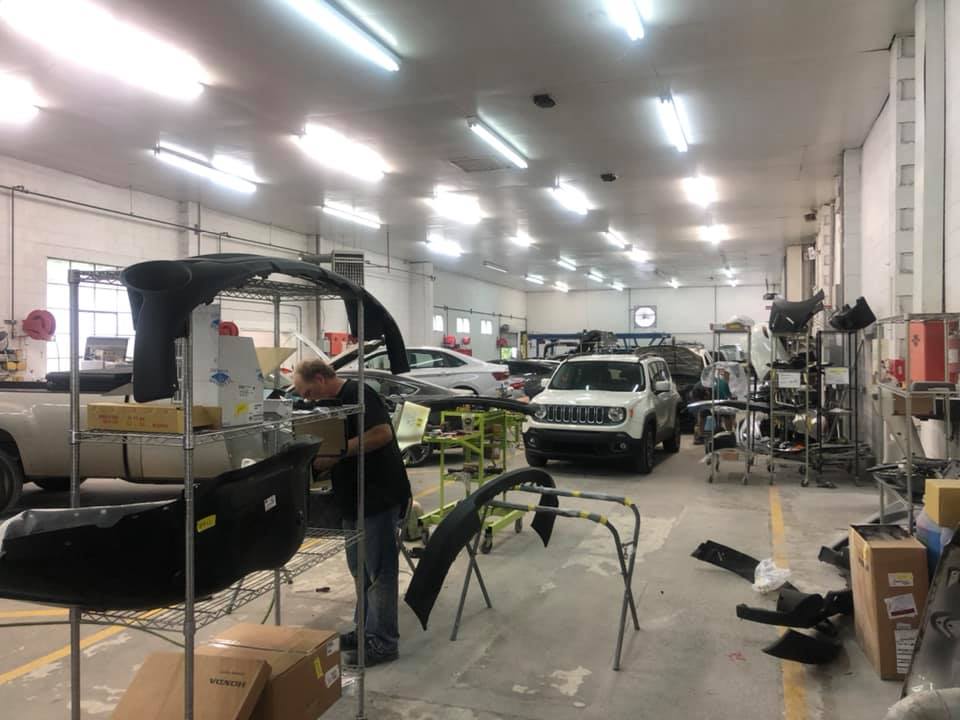 A man is working on a car in a garage.