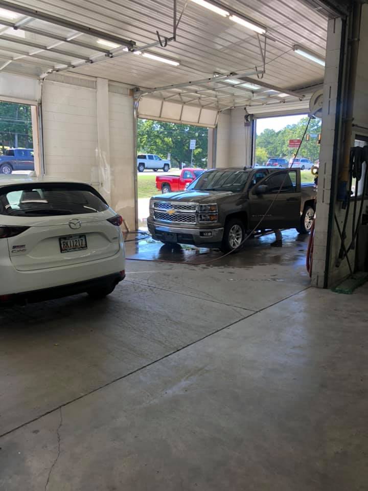 Two cars are being washed in a garage.