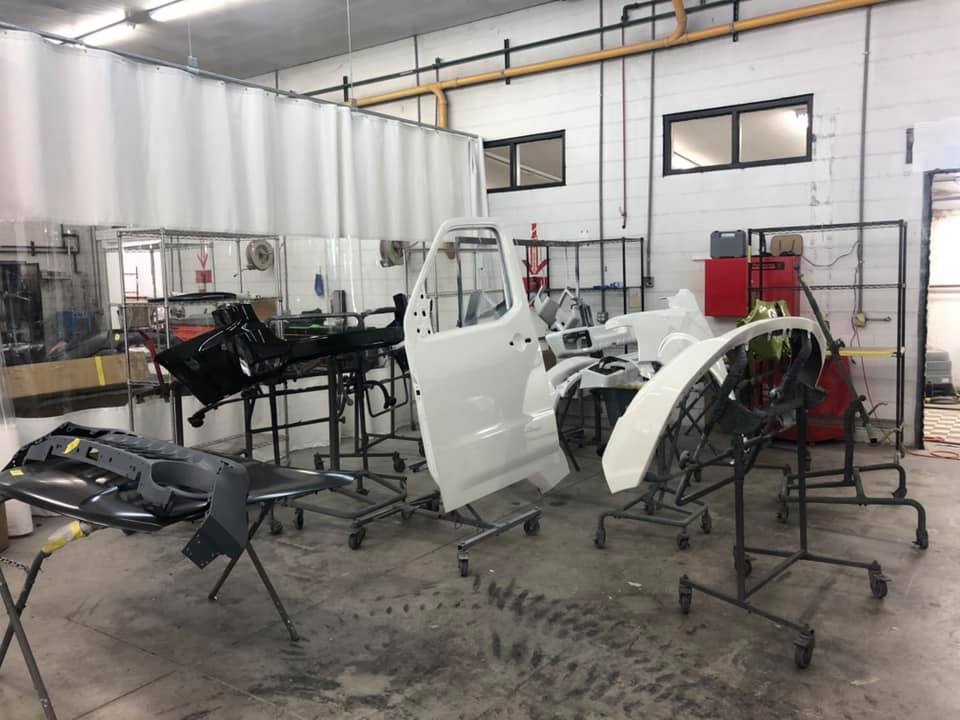 A car is being painted in a garage.