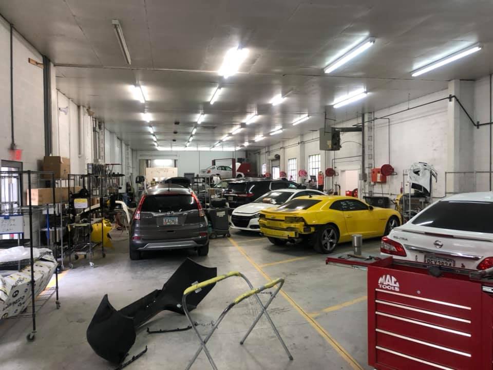 A large garage filled with cars being worked on.