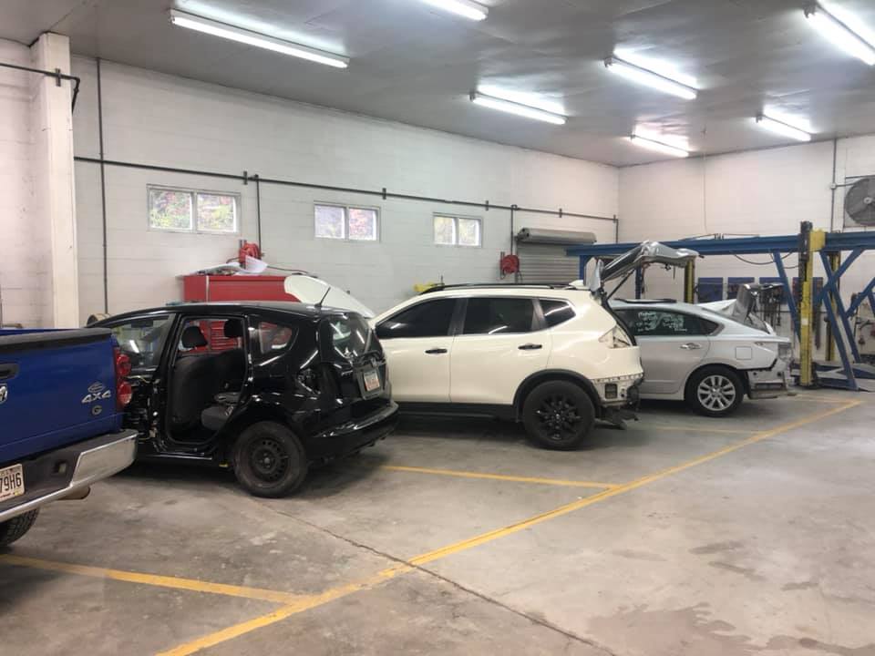 A row of cars are parked in a garage.