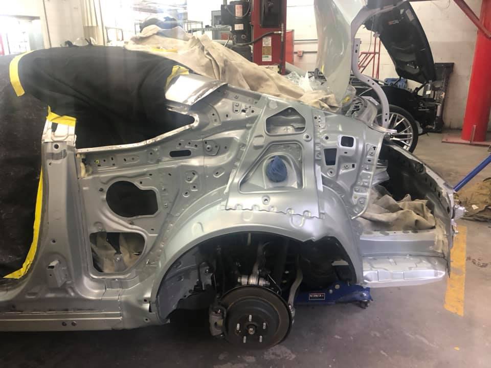 A car is being dismantled in a garage.