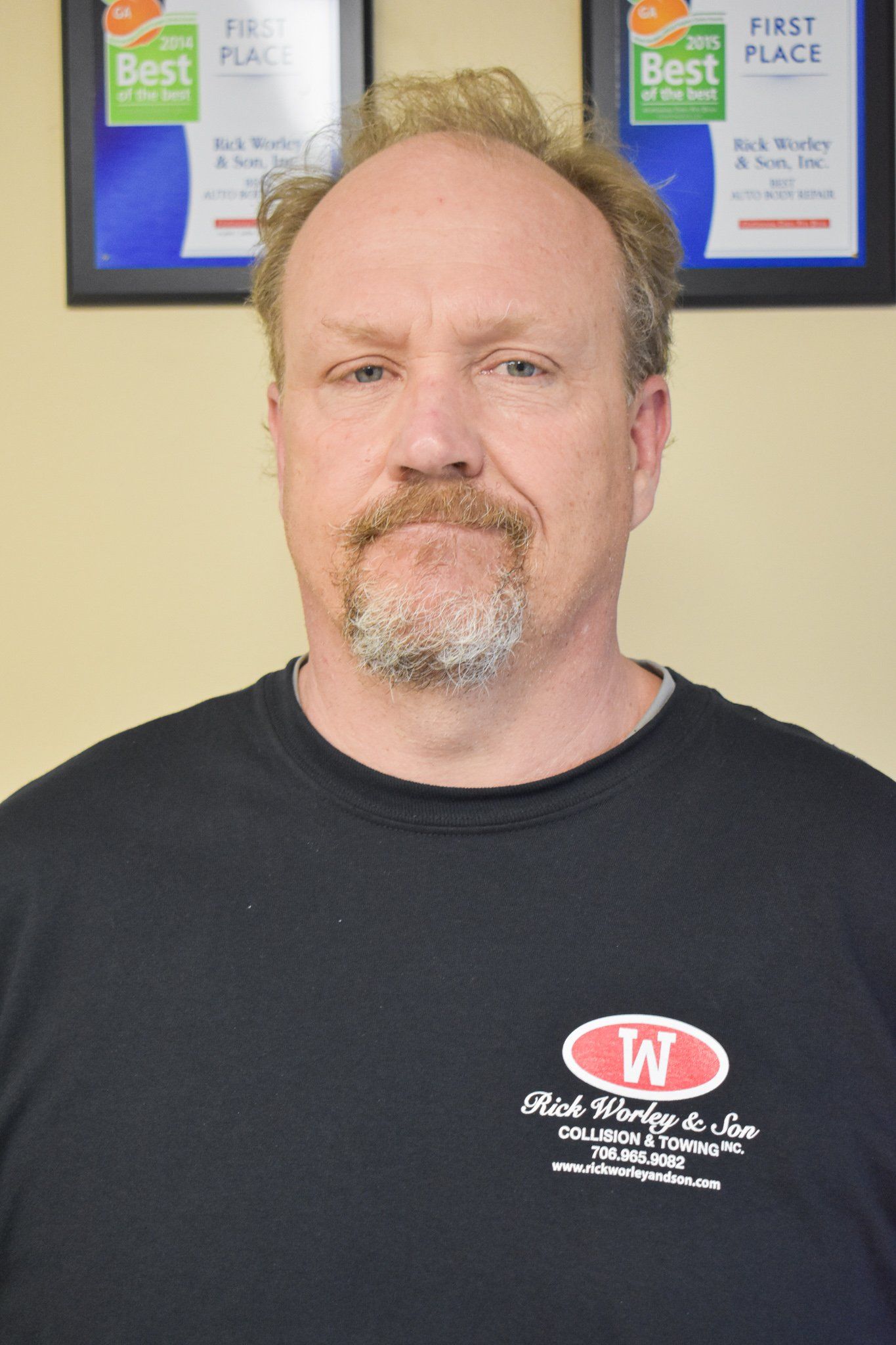 A man wearing a black shirt with the letter w on it