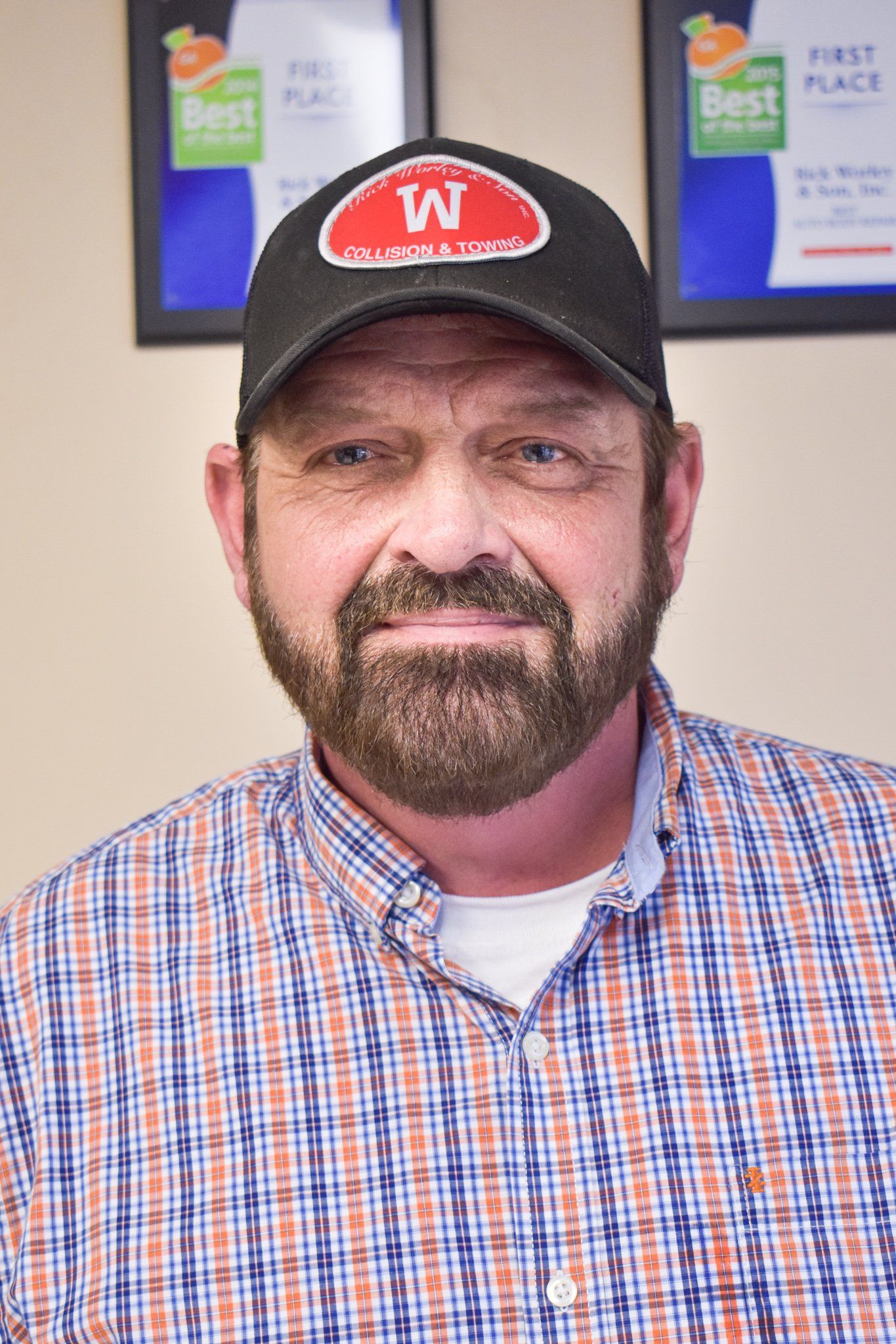 A man with a beard wearing a hat with the letter w on it