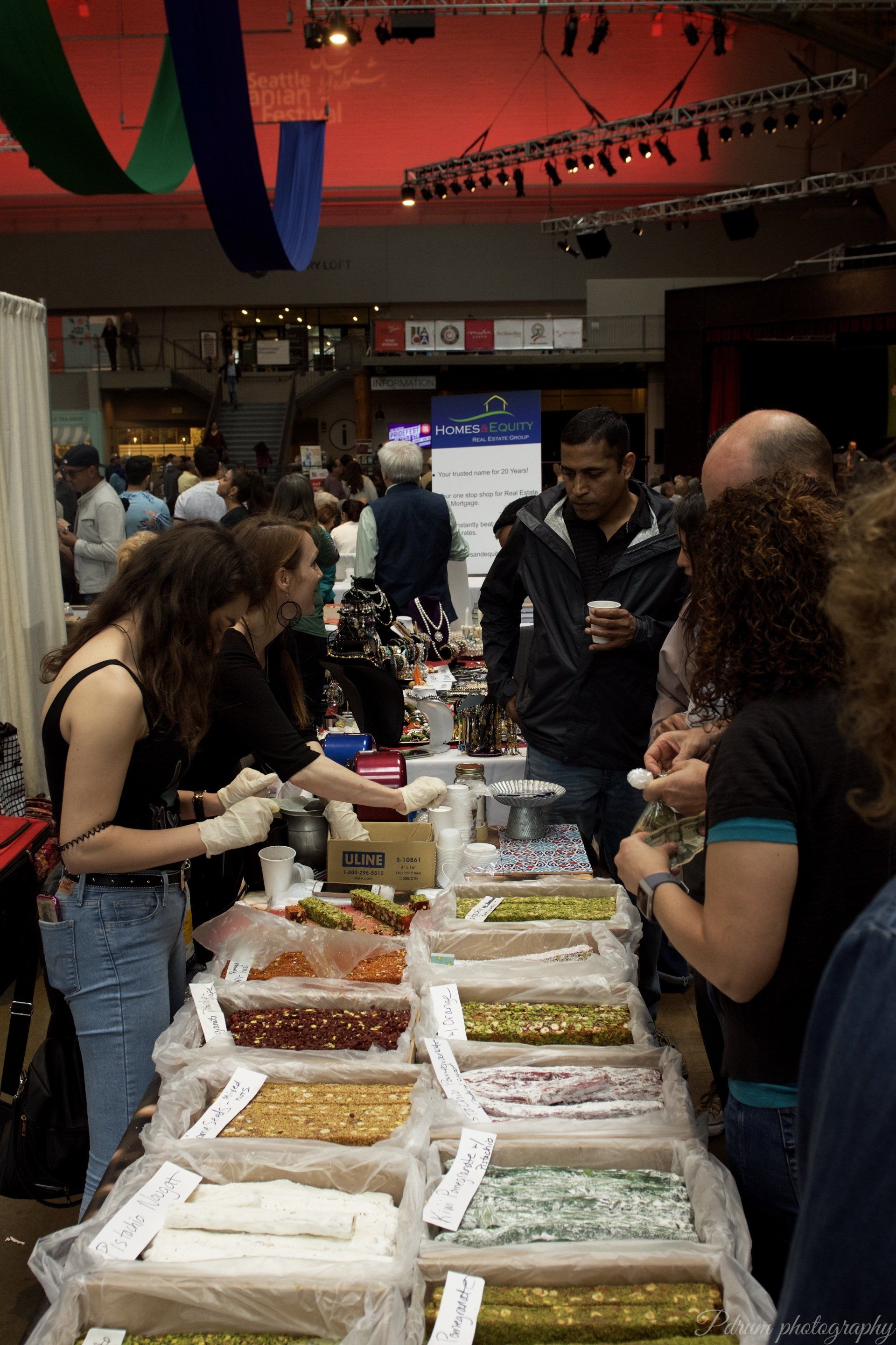 A group of people are standing around a table full of food