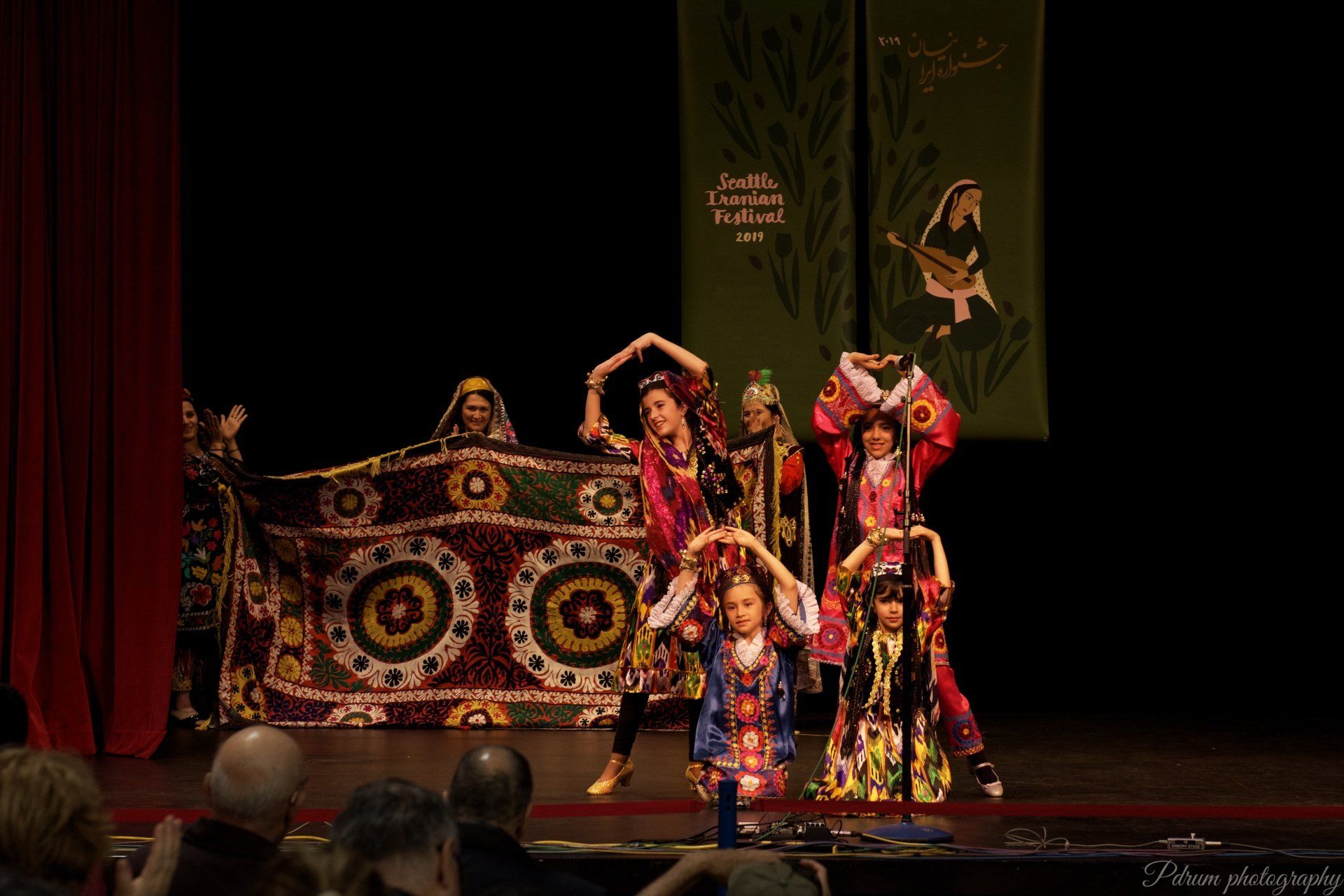 A group of people are dancing on a stage in front of a crowd.