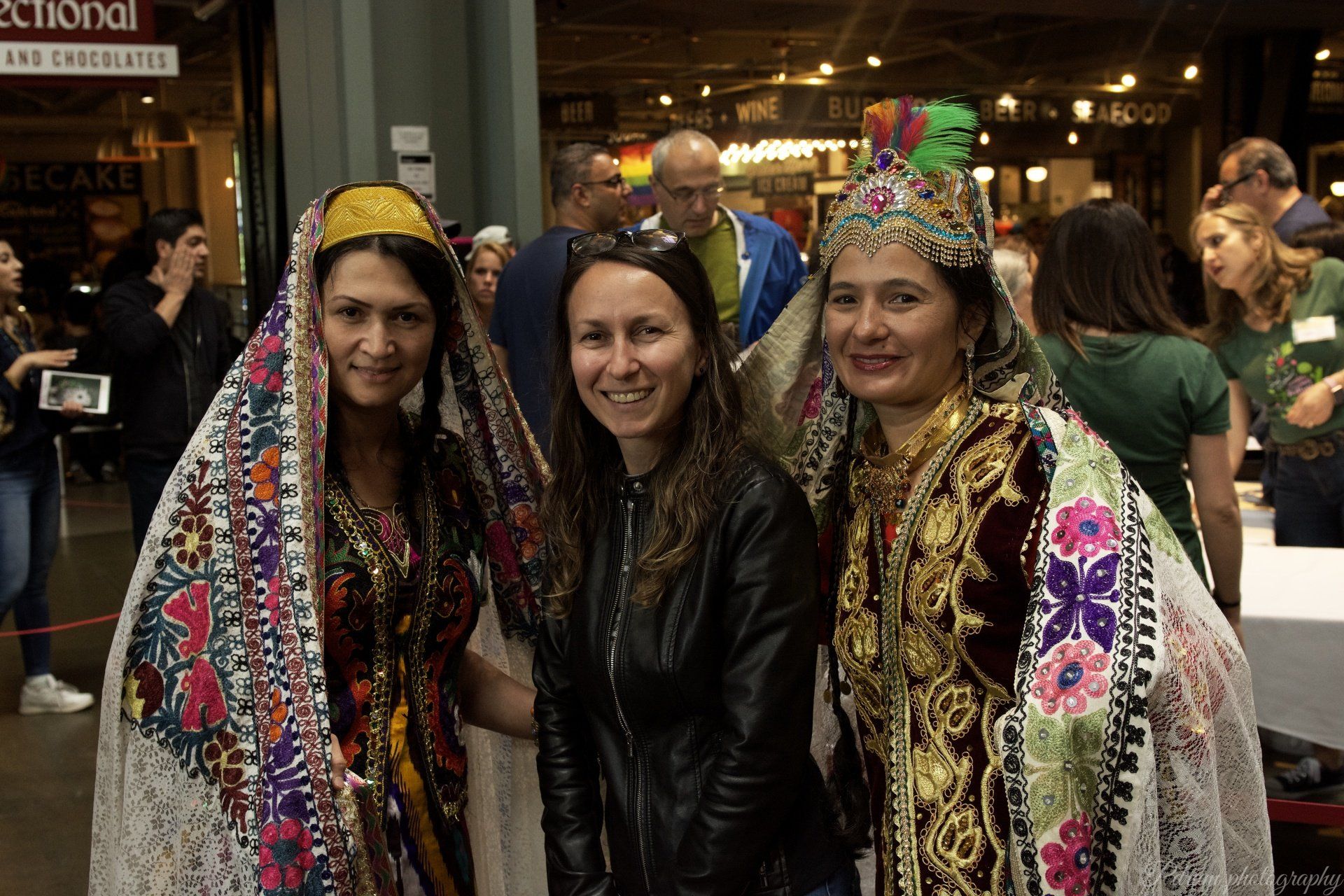 Three women are posing for a picture in front of a sign that says ' national ' on it