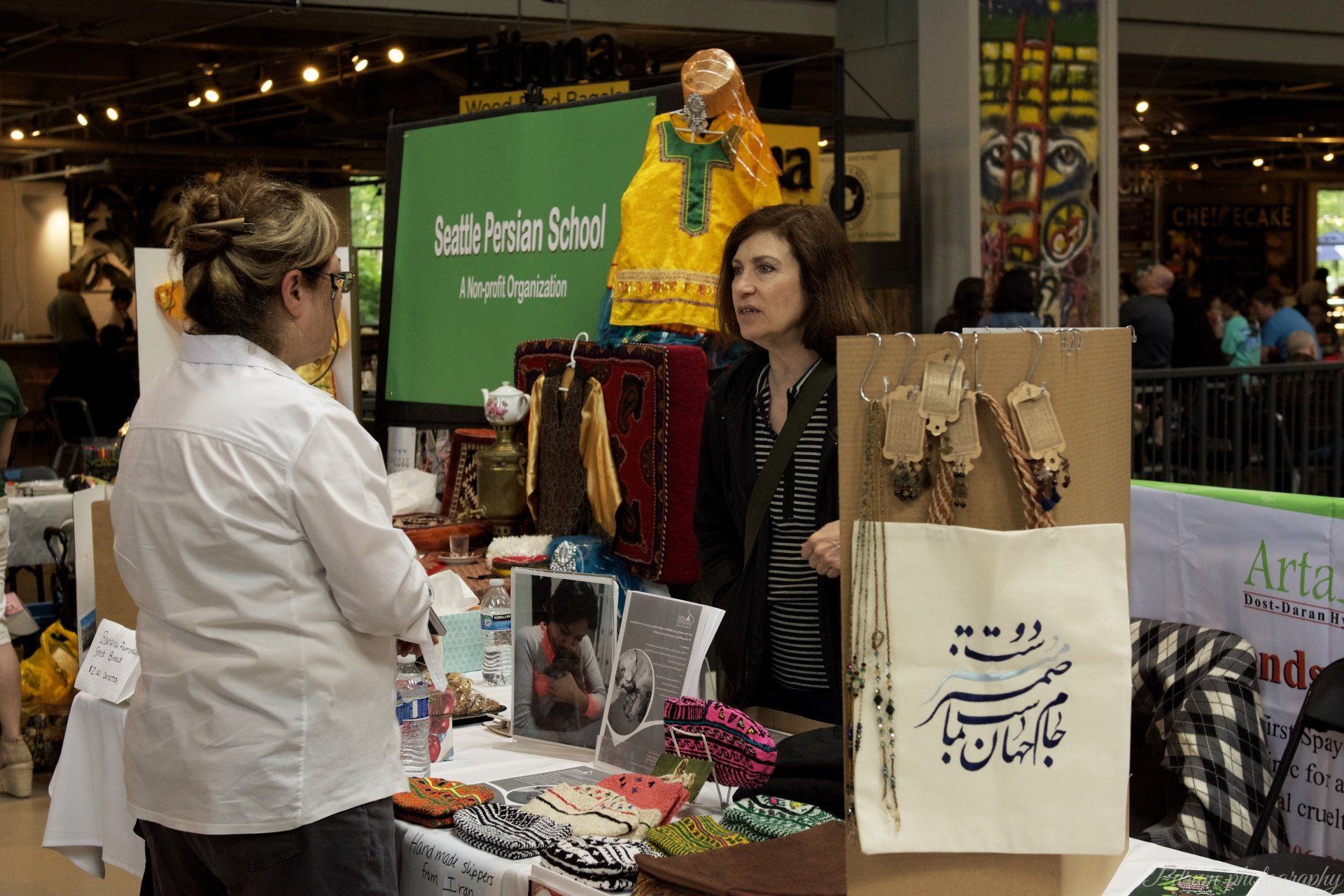 A woman in a white shirt is talking to another woman