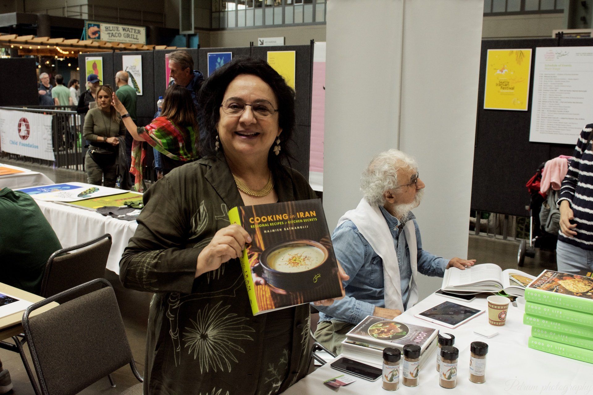 A woman is holding a book with a picture of a soup on it