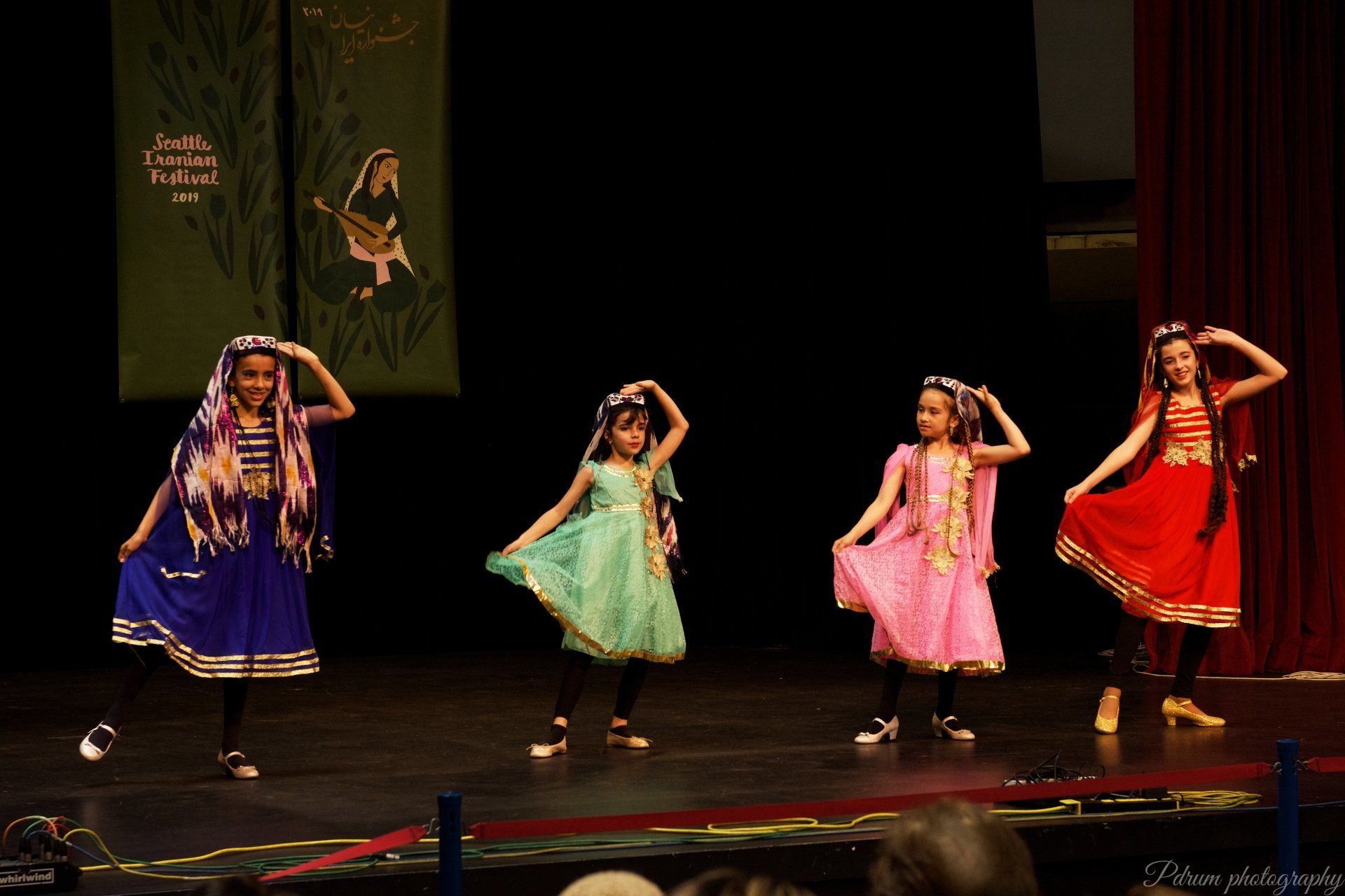 A group of young girls are dancing on a stage.
