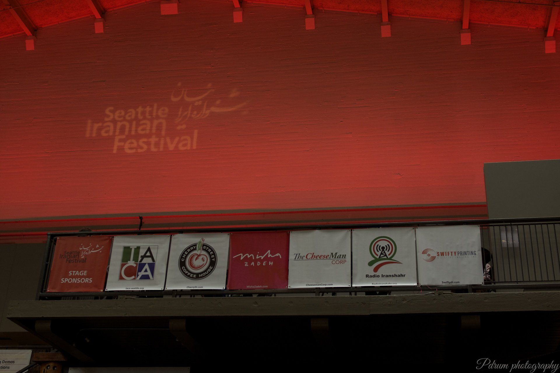 Seattle iranian festival is displayed on a red wall