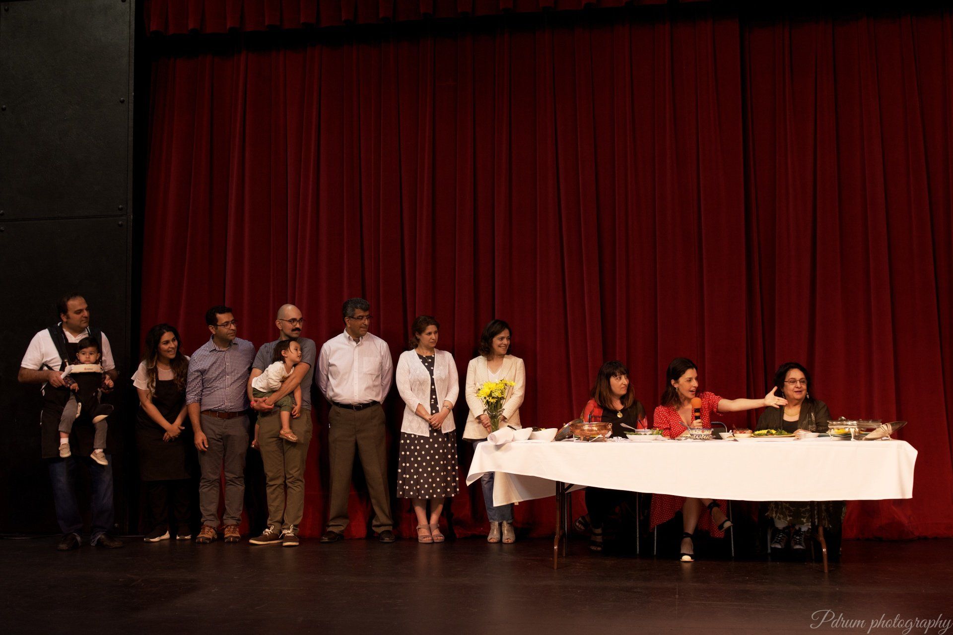A group of people standing around a table on a stage.