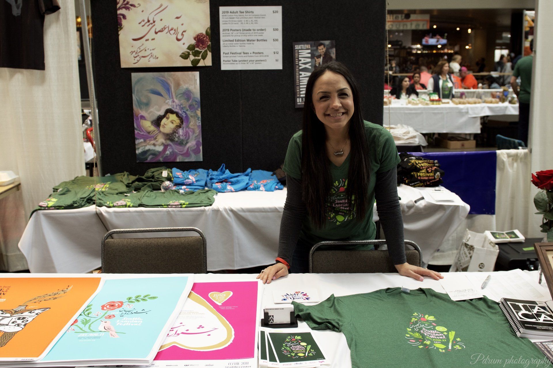A woman in a green shirt is standing at a table