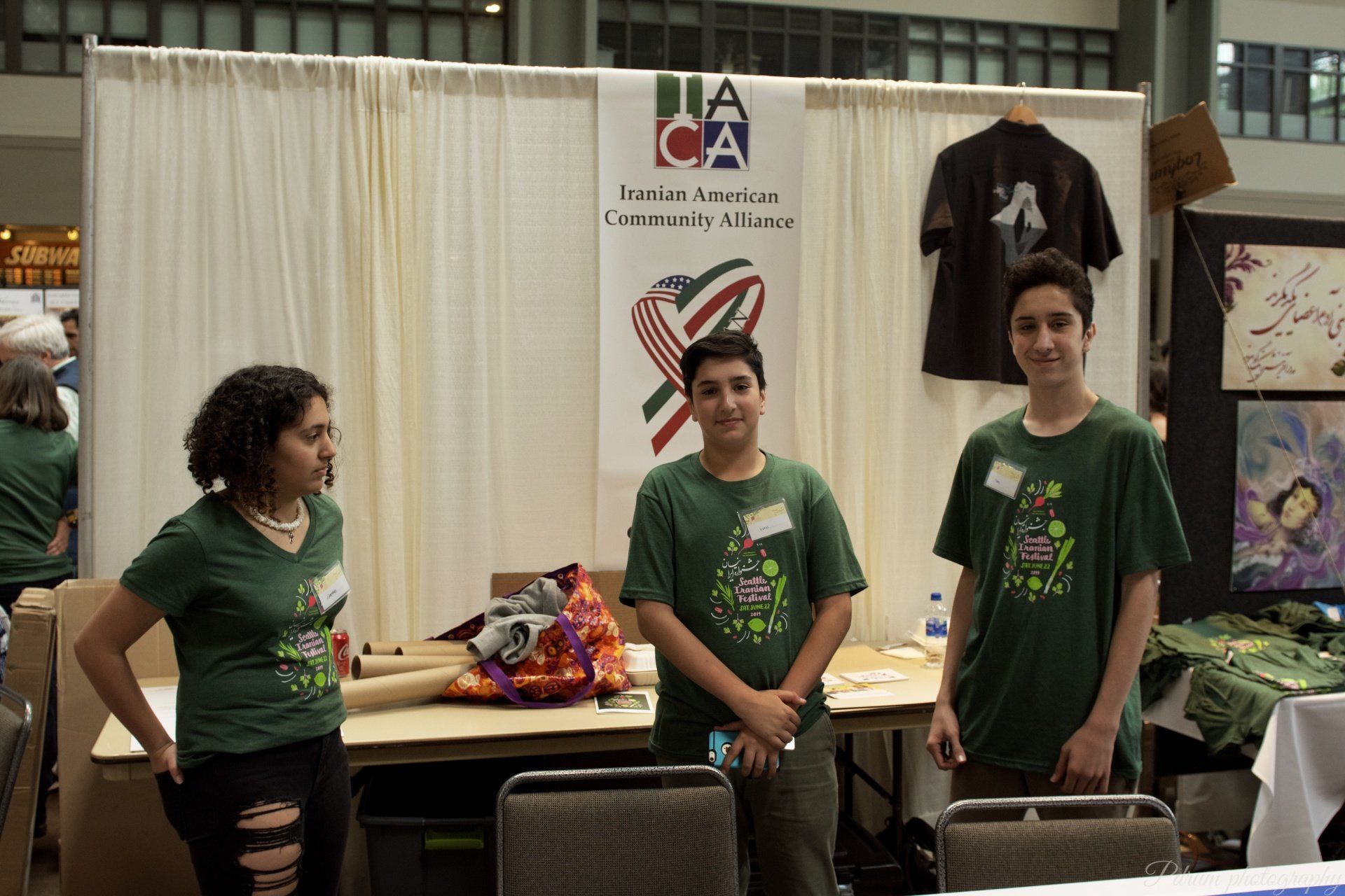 Three people standing in front of a sign that says dia ca