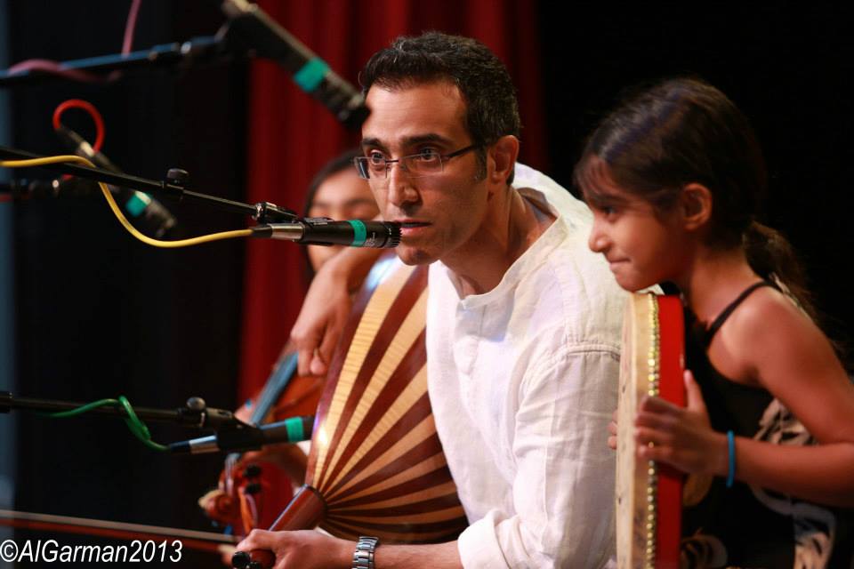 A man and a girl are playing musical instruments in a photo taken in 2013