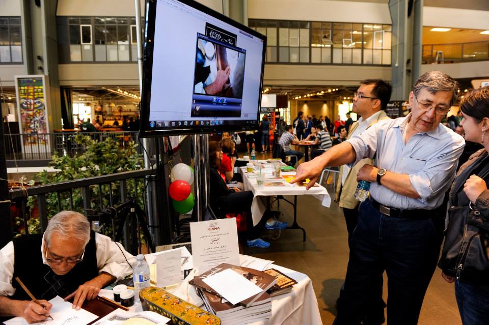 A group of people standing around a table in front of a large screen