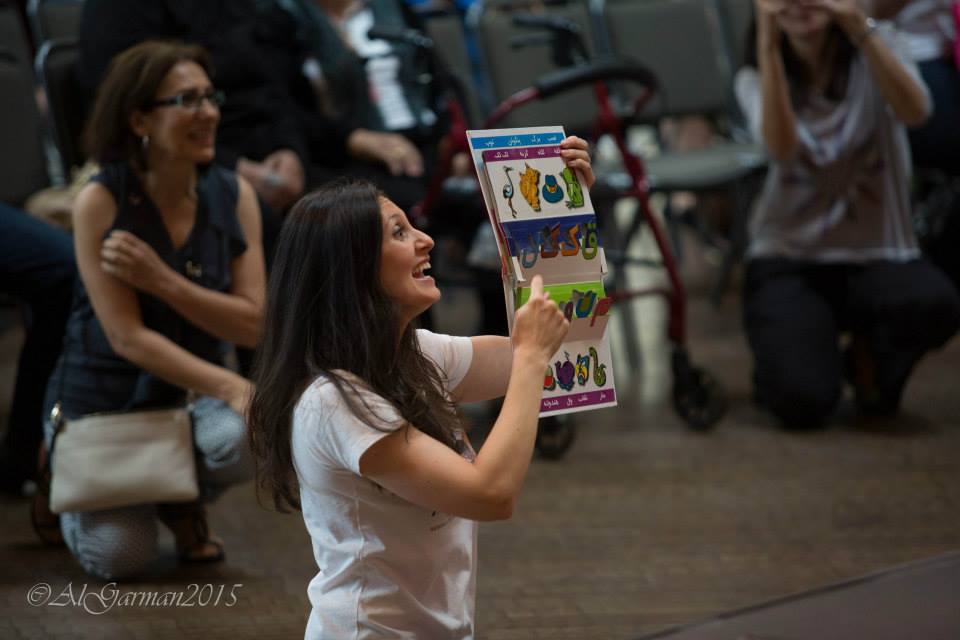 A woman is holding a piece of paper in front of a group of people.