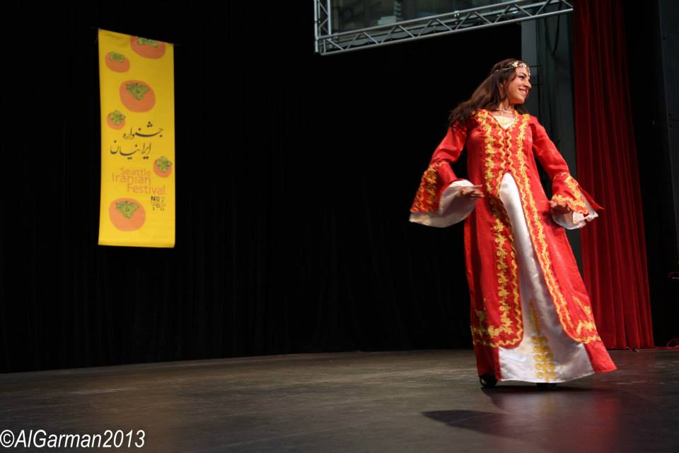 A woman in a red dress is dancing on a stage