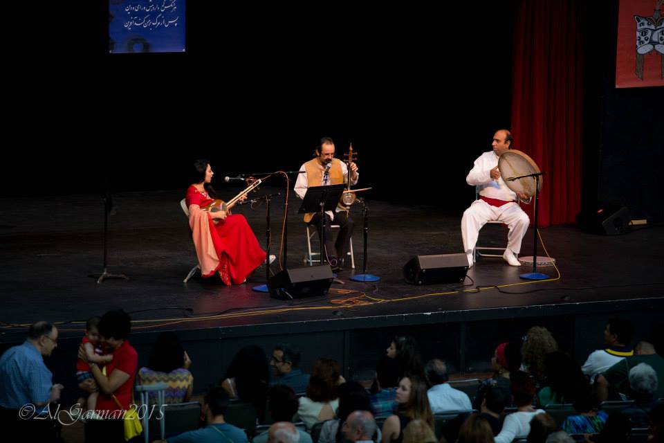 A group of people are playing instruments on a stage in front of a crowd.