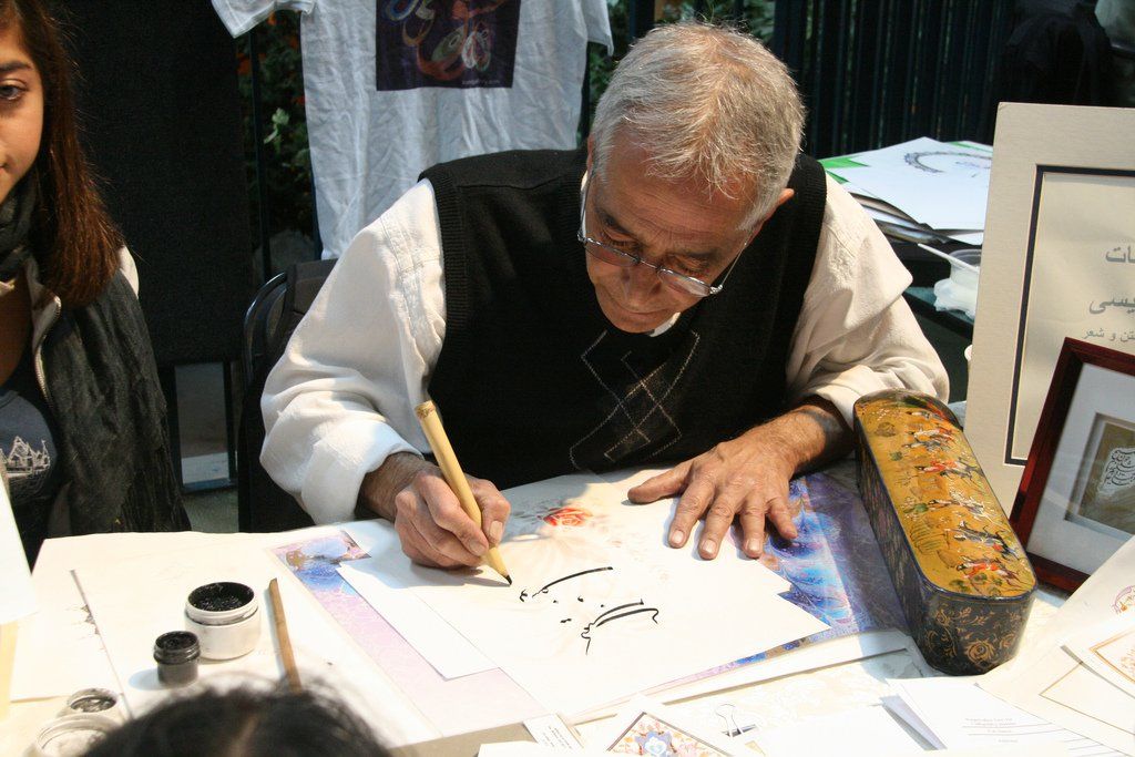 A man is writing on a piece of paper with a pen