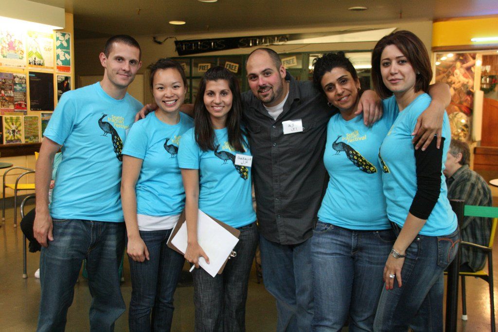 A group of people posing for a picture wearing blue shirts