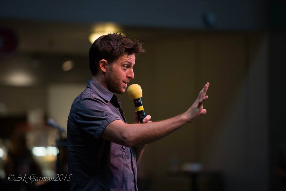 A man is holding a microphone in his hand and talking into it.