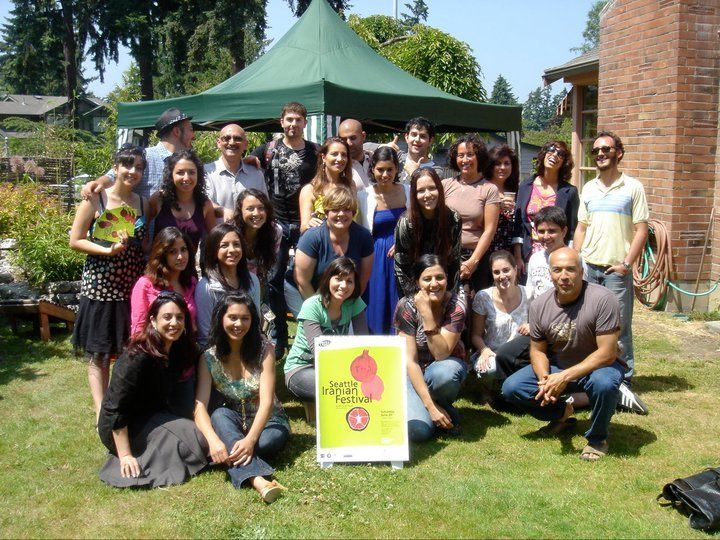 A group of people posing for a picture in front of a green tent